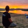 ragazzo con maglia tspace ammira il tramonto sul lago cecita in sila