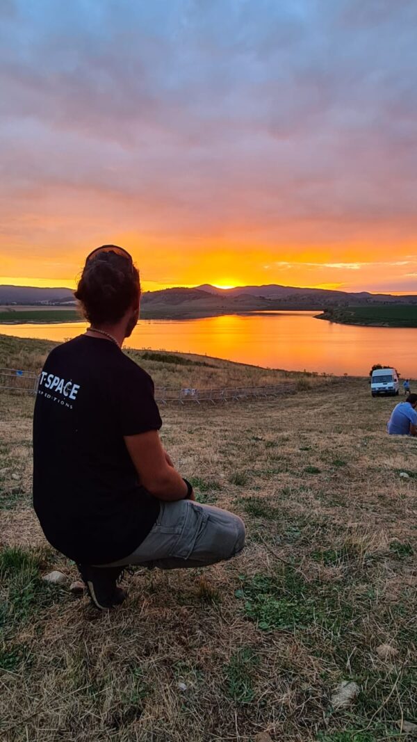 ragazzo con maglia tspace ammira il tramonto sul lago cecita in sila