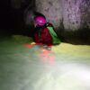caldanello night escape: ragazza che si aggira di notte in una forra immersa in acqua fino alla pancia