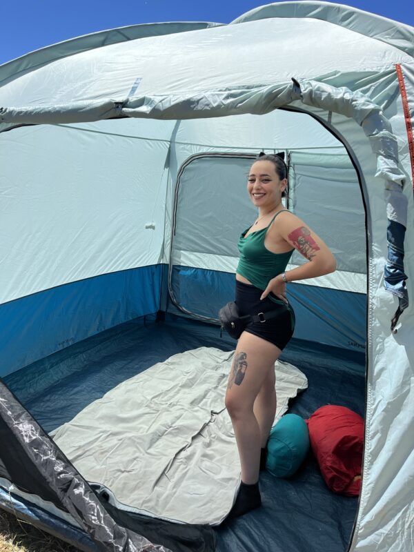 evento in Calabria dal nome emotional village a cura di Tspace: ragazza che sorride dopo aver finito di montare la tenda