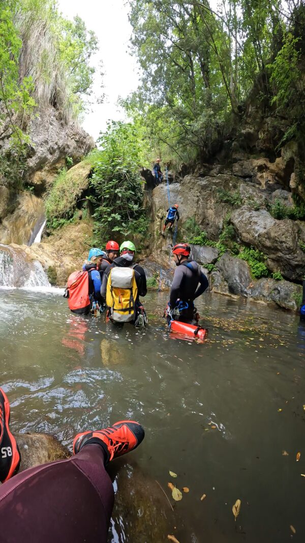 academy: introduzione al canyoning - primo gruppo attende la calata dalla cascata dei compagni