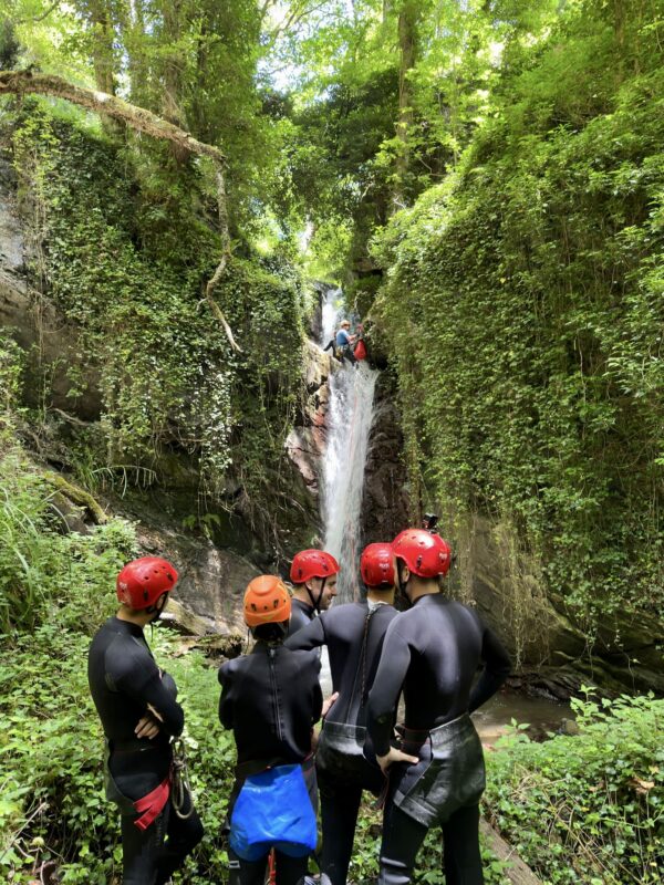 canyoning mezzanello: - calata di un ragazzo dalla cascata nel torrente mezzanello mentre altri guardano da sotto